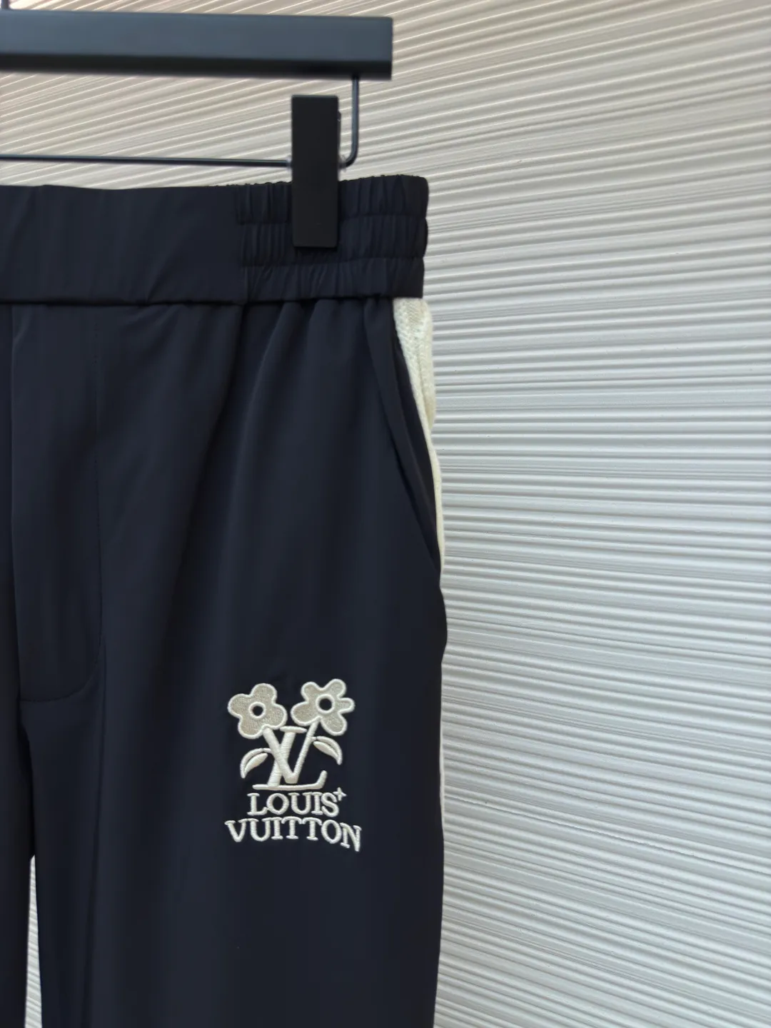 LOUIS VUITTON flower embroidered letter trousers ●Authentic product: Purchased and developed by 9250 ●Item number: 1680157-A85 ●Fabric: nylon twill fabric ●Technology: embroidery production ●Version: Fitted version ●Weight: about 400 grams ●Size: 44-46-48-50 ●Description: The fabric is made of 75D nylon twill with a rubber coating on the bottom to increase the stiffness of the fabric. The front panel is embroidered with a Tajima embroidery machine imported from Japan. The side webbing pieces are all marked with a dot pen by hand. The flat car is used to stitch the webbing back and forth to ensure that the woolen webbing fits smoothly on the cut pieces. The overall routing is straight and delicate. The fabric is comfortable and soft. The color is consistent and has no color difference. It can be matched with the same style to create a fashionable look and control various occasions. Customized accessories, complete three labels, same style for men and women!